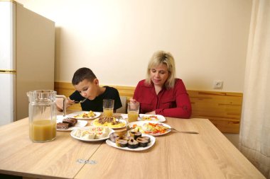 Festival masasında, anne ve oğluna yiyecek ve içecek ikram edilir..