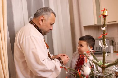 Ukrayna nakış işindeki bir adam ve oğlu Noel ağacı süslemişler..
