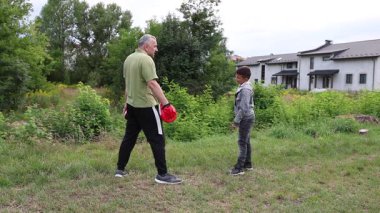 Çocuk, Green Park 'ta yetişkin koçuyla boks antrenmanı yapıyor..