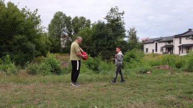 Çocuk, Green Park 'ta yetişkin koçuyla boks antrenmanı yapıyor..