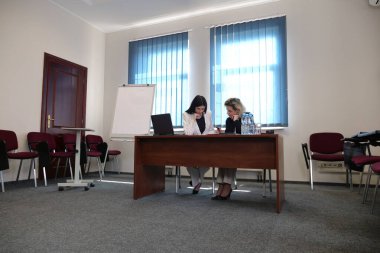 İş sunumunda kadınlar, strateji tartışması yaparken tablolarda listelere işaret ediyorlar.