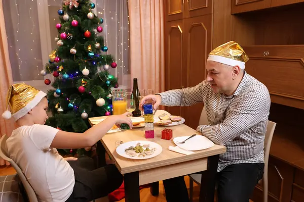 Baba oğul Noel 'i ya da yeni yılı bir şenlik masasında kutluyorlar.