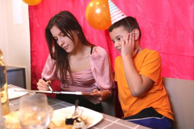 İnsanlar festival masasında otururken tahtaya resim çizerken eğleniyorlar. Yumuşak ışıklandırma.