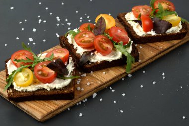 Domates, roka ve yumuşak peynirli ahşap tepside