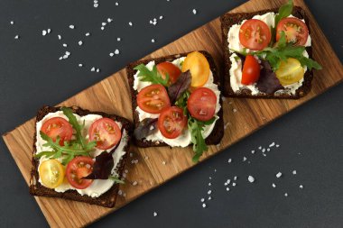 Domates, roka ve yumuşak peynirli ahşap tepside