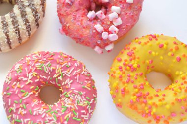 Beyaz arka planda serpiştirilmiş renkli çörekler.