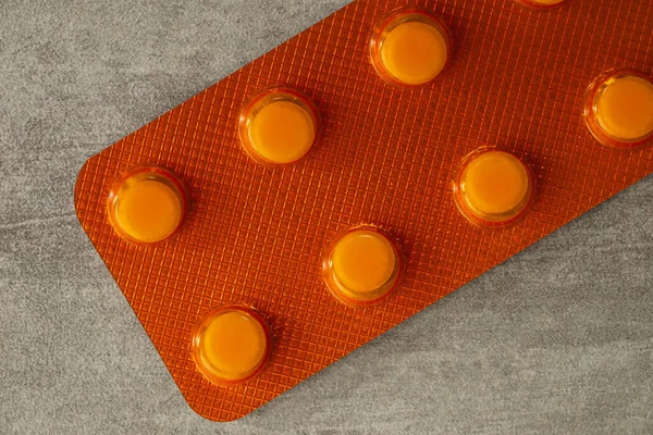 Masada turuncu ya da sarı haplar, üst görünüm ya da hapların yakın çekim