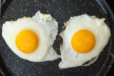 Elektrikli sobanın üstünde tavada kızarmış yumurta..