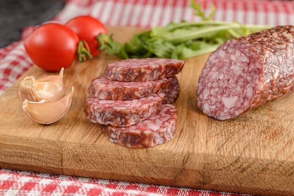 Salamlı sosis dilimleri domatesli ve sarımsaklı ahşap arka planda