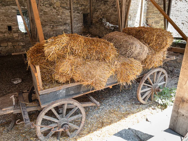 Eski binanın içinde saman balyaları olan ahşap araba.