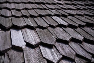 Eski ahşap çatı kiremitlerinin detaylı bir yakın plan görüntüsü, yıpranmış ahşabın doğal dokusunu ve tahılını gösteriyor..