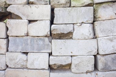Yıpranmış taş duvar dokusu. Düzensiz bloklar, yaş ve hasar gösteriyor. Arkaplan veya tasarım için harika.
