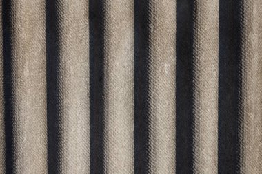 Bükülmüş yüzeyin yakın çekim dokusu, alternatif ışık ve koyu dikey çizgiler gösteriyor. Arkaplan ya da tasarım ögeleri için ideal.