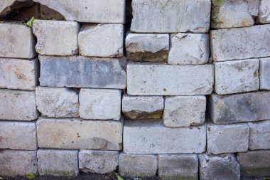 Eski, yıpranmış, gözle görülür hasarlı ve yıpranmış bir duvara yakın plan. Düzensiz şekiller ve renkler yaş ve bozulmayı gösterir.