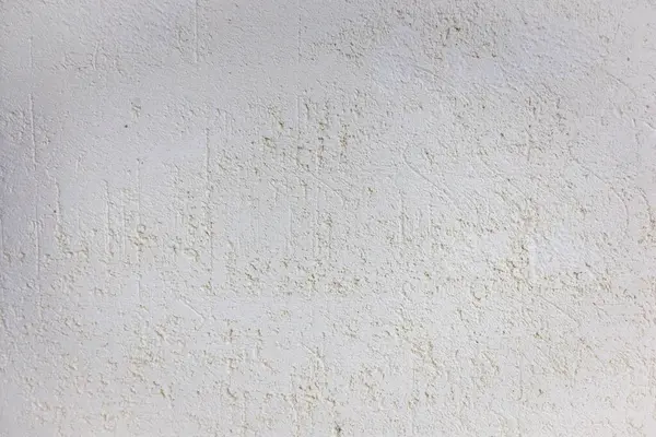Beyaz, desenli, hafif renk değişimi ve kusurları olan bir duvar yüzeyinin yakın plan görüntüsü.