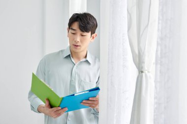 Genç Asyalı Adam Parlak Modern Ofiste Yeşil Dizini Tutuyor