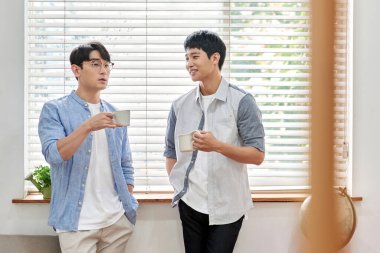 Parlak Modern Oturma Odasında Genç Asyalı Erkekler Kahve ve Sohbet Ediyor