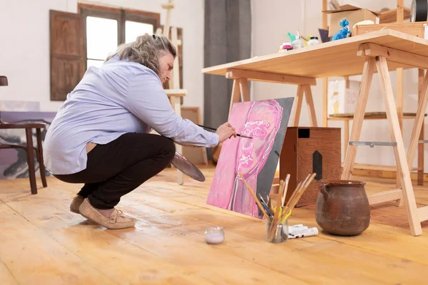 Mature Artist Woman Paints Canvas While Squatting Her Workshop She — Stock Photo, Image