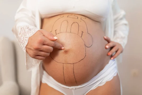 Close Van Een Zwangere Vrouw Geschilderd Buik Knop Terwijl Wijst — Stockfoto