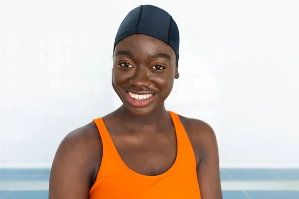 一个戴着游泳帽的漂亮黑人年轻女子的画像 她用相机看着加热的游泳池 — 图库照片