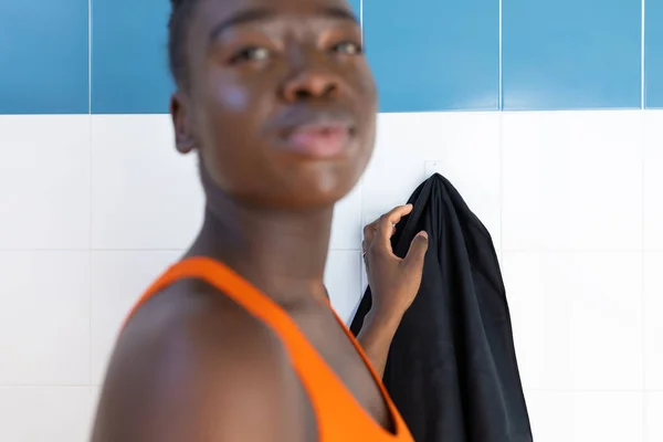 年轻的黑人妇女把毛巾挂在加热的游泳池边 — 图库照片
