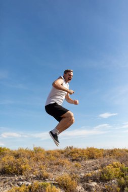 Bir adam zıplar ve stres atmak için bağırır kırsal alanda egzersiz yaparken sağlıklı bir yaşam tarzı sürdürmek için.
