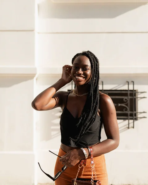 Uma Jovem Negra Sorri Feliz Enquanto Corrige Cabelo Com Mão — Fotografia de Stock