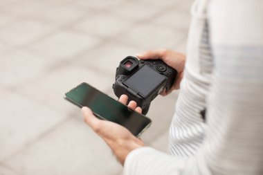 Genç bir adam, İspanya 'da seyahat ederken arkadaşlarıyla sosyal ağlarda paylaşmak için kamerasından akıllı telefonuna fotoğraf aktarıyor..