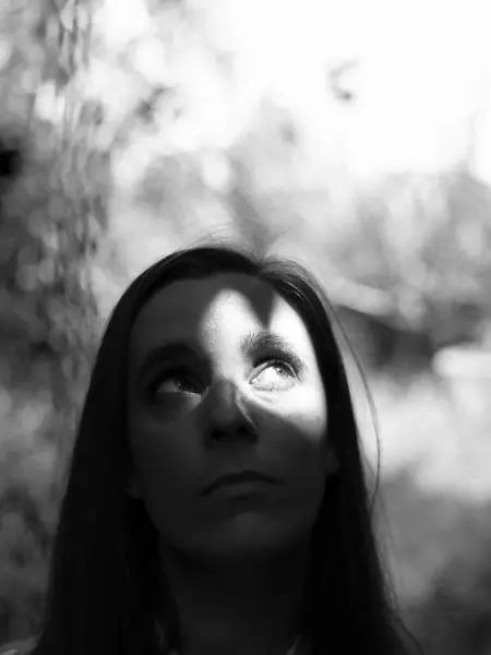 Молодая Женщина Смотрит Вверх Серьезным Вдумчивым Лицом Время Луч Света — стоковое фото