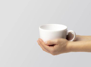 Geniş bir kase beyaz çorba, genç bir kadının ellerinde, arka planda izole edilmiş.