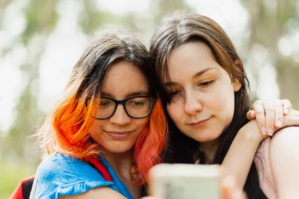 Две Молодые Девушки Обнимаются Глядя Мобильный Телефон Сделать Селфи Стоковое Фото
