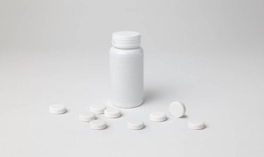 Kapalı aspirin şişesinin maketi, beyaz renk, plastik malzeme, beyaz etiket, telif alanı olan beyaz arkaplan