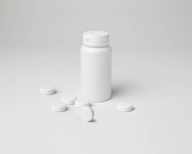 Küçük boyutta kapalı bir aspirin şişesinin kopyası, beyaz arka planda kopyalanmış.
