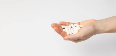 Bir kadının elinde bir avuç dolusu D3 vitamini kapsülü, besin takviyesi, beyaz arka planda, kopyalanmış...