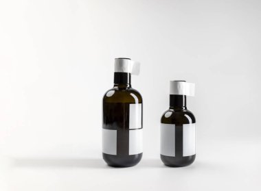Modern prim ekstra saf zeytinyağı şişeleri, beyaz arka planda kopyalanmış, 500 ml ve 250 ml, gerçek fotoğraf