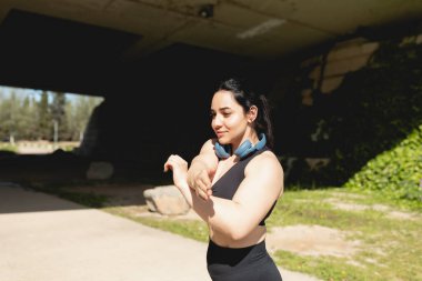 Genç bir kadın, İspanya 'nın Zaragoza kentinde yapılan antrenman sırasında kolları ve omuzlarını esnetme egzersizleri yapıyor.