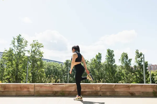 Bir kadın yurtdışındaki bir egzersiz seansında bacaklarını dinlendiriyor, Zaragoza, İspanya