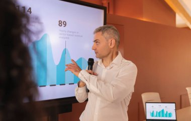 Latin hatları olan bir kadın, ofisin ortak ofis alanında bir mola sırasında iş arkadaşıyla konuşur.