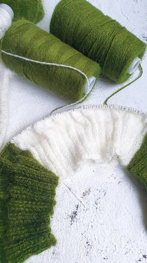 El yapımı kazak. Vizon ipliğinden örülmüş kumaş. Beyaz ve zeytin rengi. Boşluğu kopyala.