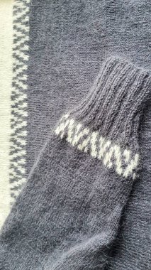 El yapımı kazak. Vizon ipliğinden örülmüş kumaş. Beyaz ve gri renk deseni. Boşluğu kopyala.