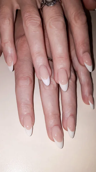 Acrylic nail extension, manicure, nail correction, hands in the foreground. Reflective design. copy space