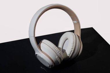 Koyu arkaplanda bej kablosuz kulaklık. İzole et. Müzik dinlemek için suç ortağı. Boşluğu kopyala
