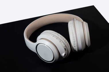 Koyu arkaplanda bej kablosuz kulaklık. İzole et. Müzik dinlemek için suç ortağı. Boşluğu kopyala