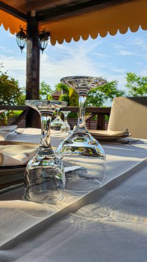 Tatil için çardakta masa hazır. Yüzeyde gözlük ve tabaklar var. Boşluğu kopyala
