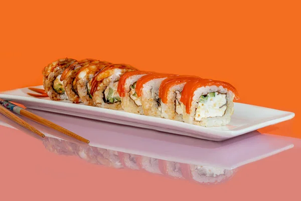 寿司套餐 滚与鱼子酱 金枪鱼和鳄梨和费城奶酪 在一个白盘 在一个彩色的背景 复制空间 — 图库照片
