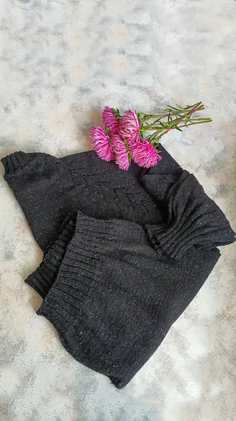 Handmade knitted products. Knitted sweater made from tweed threads. Gray background. Copy space