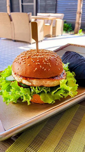 Fresh grilled burger with beef patty, tomatoes, cheese, cucumber and lettuce. Copy space