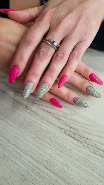 Acrylic nail extensions, manicure, nail correction, hands in the foreground. Reflective design. Copy space