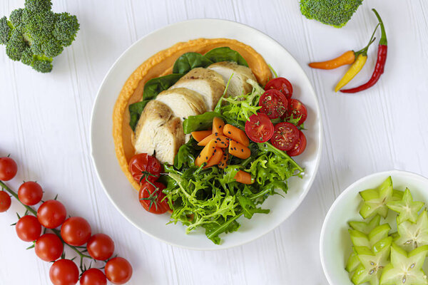 Baked chicken with vegetables, pumpkin puree and arugula. Keto diet food. Copy space