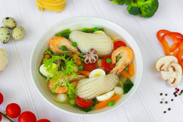 Seafood soup with squid, shrimp and boiled egg. Diet food. Copy space